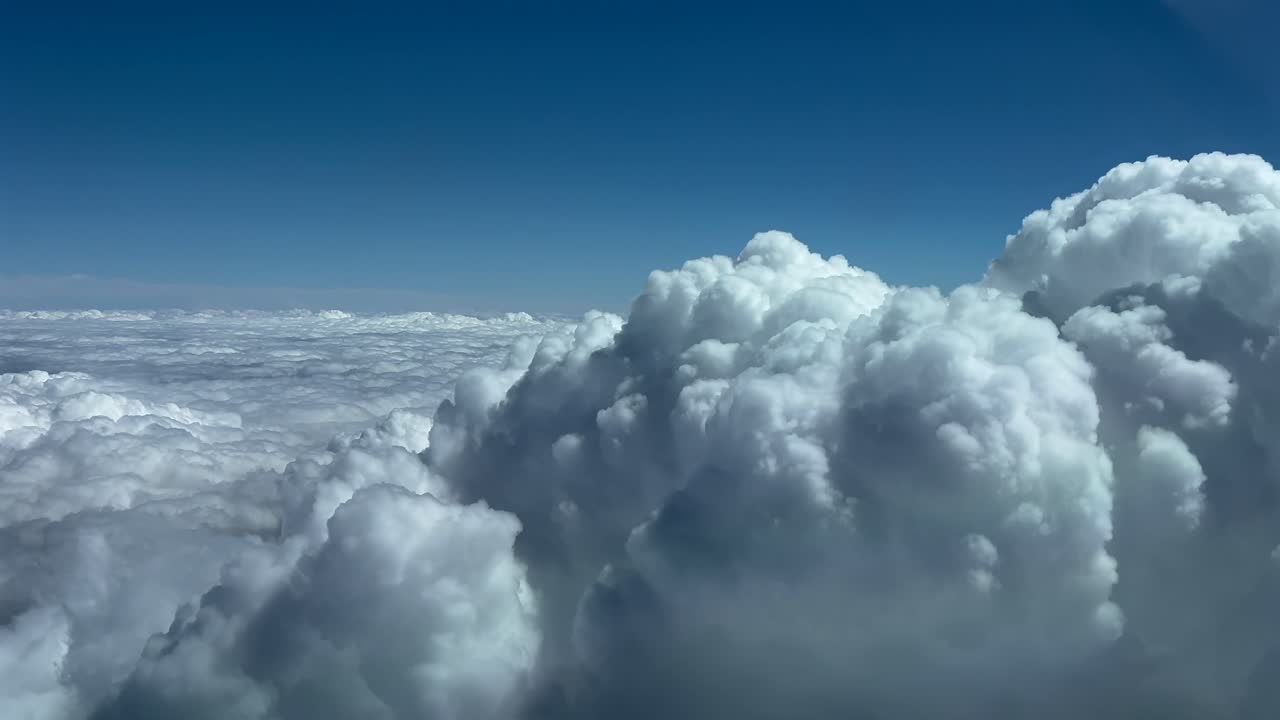 pov volando cerca de la parte superior de una enorme nube de tormenta cumulonimbus, como lo ven los pilotos de un avión a reacción