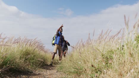 African-american-couple-walking-while-trekking-in-the-mountains