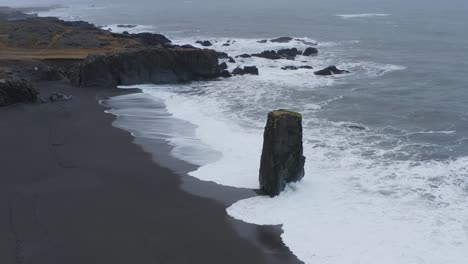 foamy waves hit on stapi sea stack at stapavík in south west iceland