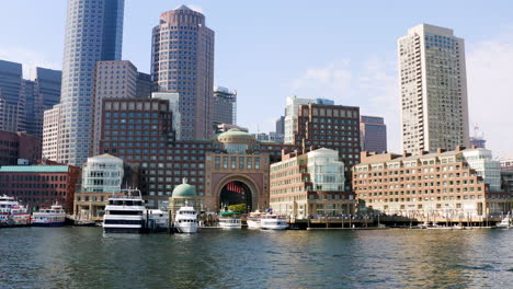 low drone shot of boston skyline from boston harbor