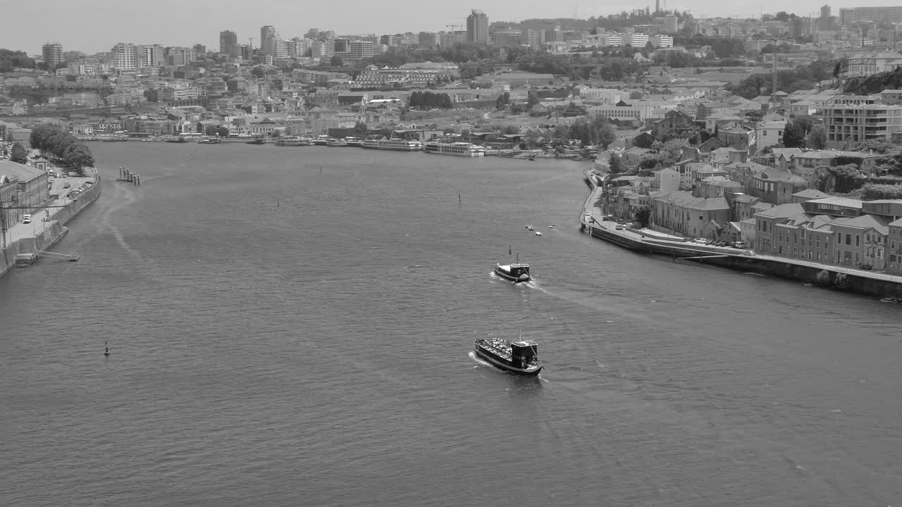 fotografía en blanco y negro sobre oporto y vila nova de gaia separadas por el río duero en oporto, portugal durante el día
