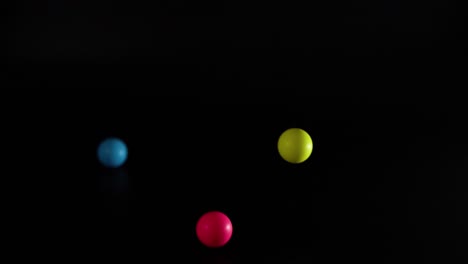 vibrant balls bouncing against a dark background