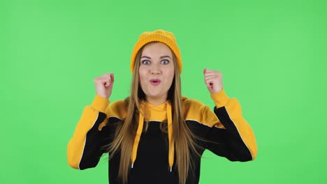 portrait of modern girl in yellow hat with shocked surprised wow face expression and having fun. green screen