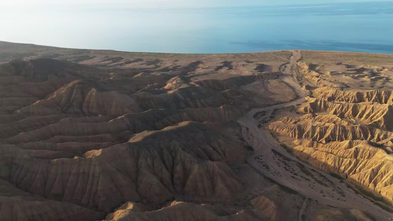 drone approach beach in Issyl Kol lake , travel destination in Kyrgyzstan at sunset coming from Ak Sai Canyons The Valley of Forgotten Rivers