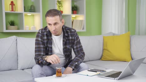 Gloomy-pensive-man-sitting-on-sofa-and-looking-depressed.