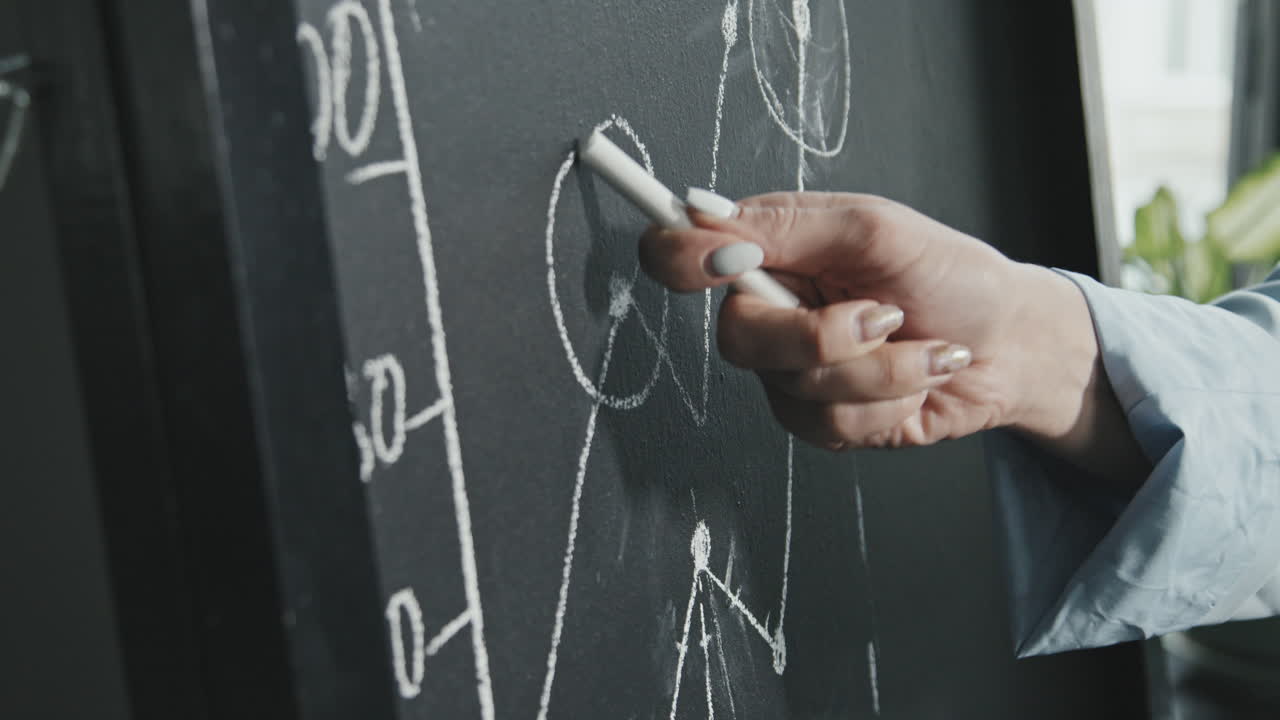 Businesswoman Drawing Finance Graph on Chalkboard
