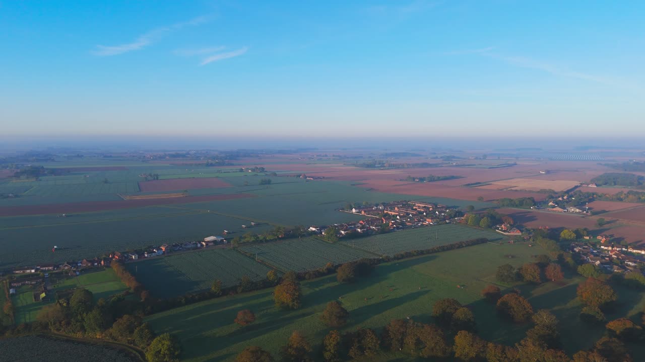 Misty autumn morning with farmlands and countryside views, wide vistas across open fields with crops set for overwintering. cold days in a rural village setting