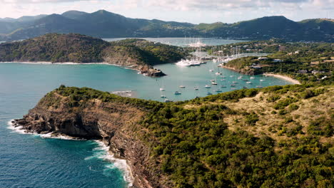 Sonnige-Luftaufnahme-Des-Englischen-Hafens-In-Antigua,-Karibik-Mit-Blick-Auf-Yachten,-Segelboote,-Marina,-Bucht-Und-Klippen