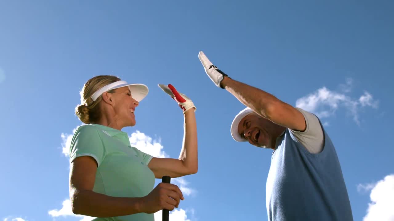 골프 코스에서 골프를 치는 커플 하이파이빙