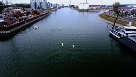 paddlers in canoe and kayak training in an industrial port filmed by a drone in germany