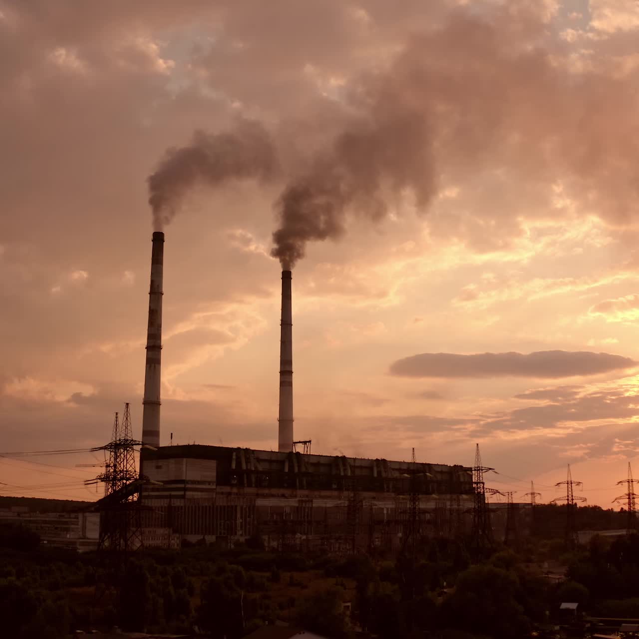 Industrial zone with thick smog from pipes. Factory zone pollutes the atmosphere. Factory chimneys with dirty emissions on the evening sky background. Camera rising