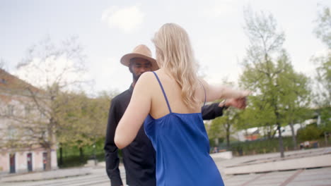 interracial couple dancing salsa in a public square 1