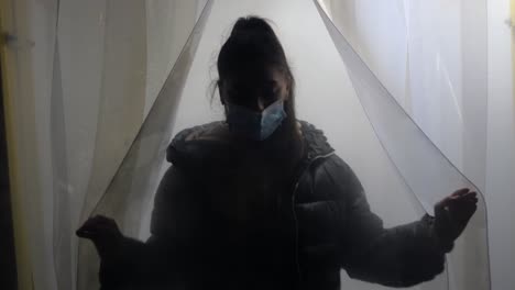 chica con máscara detrás de una cortina