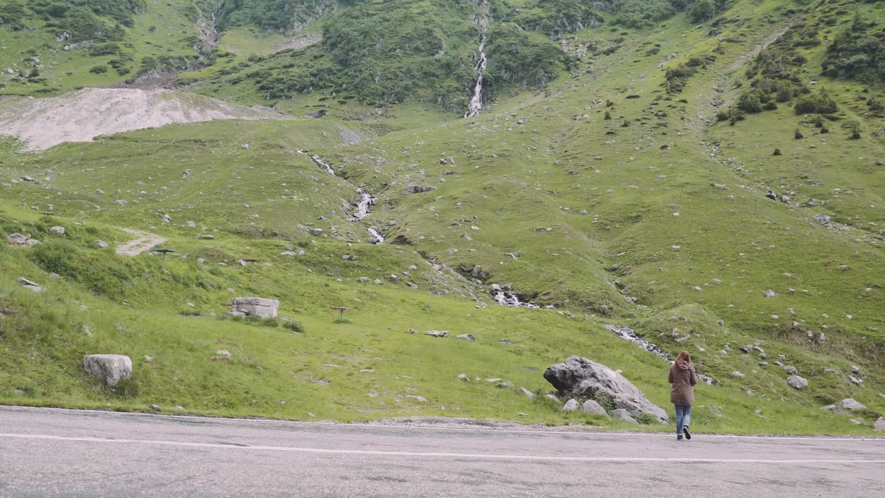 젊은 여성 하이커가 사진 카메라로 산을 등반합니다. 트랜스파가라산, 루마니아의 카르파티아 산맥