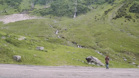 a young woman hiker climbs mountains with photo camera. transfagarasan, carpathian mountains in romania