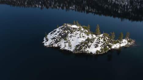 frozen fannette island floats in a blue black sky reflected in the still waters of emerald bay lake tahoe