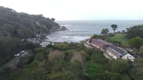 Aerial-drone-flying-over-coastal-town-in-a-valley-going-out-to-sea---Lee-Bay,-Beach,-Ilfracombe,-Devon,-England