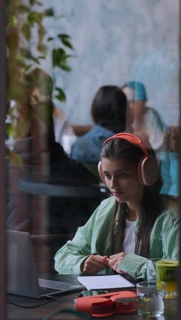 una mujer joven estudiando en un café.