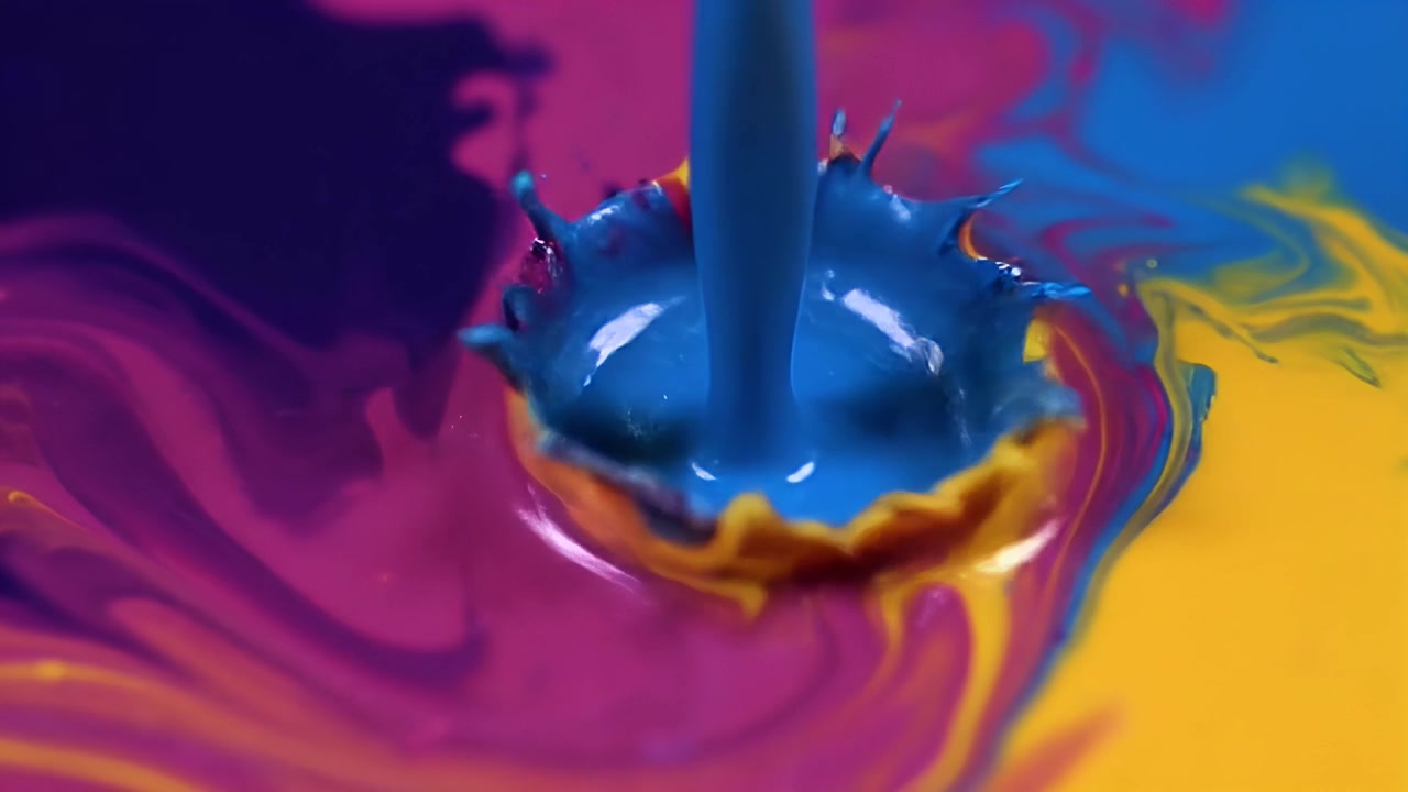 Pintura azul vertiéndose en líquido vibrante amarillo y morado