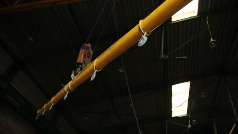 close-up view of a crane transporting a big steel construction in a factory