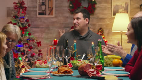 familia feliz mientras la joven madre sirve delicioso pollo