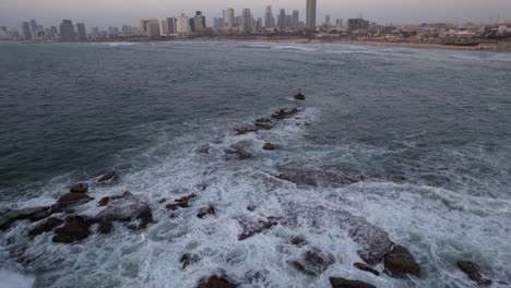 vista aérea sobre las rocas de andrómeda, revelando la ciudad de tel aviv, israel - inclinación, disparo de drones