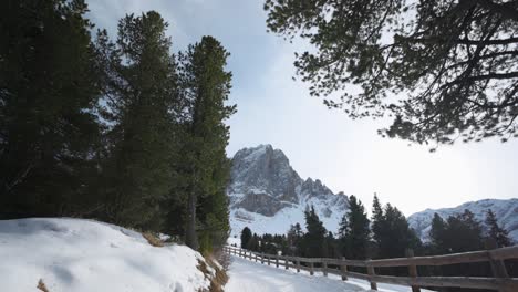 walking on snowy trail on a sunny day with peitlerkofel mountain on background