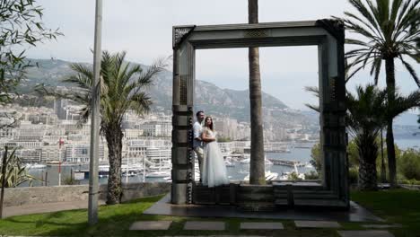 couple posing in front of a frame overlooking the monaco cityscape