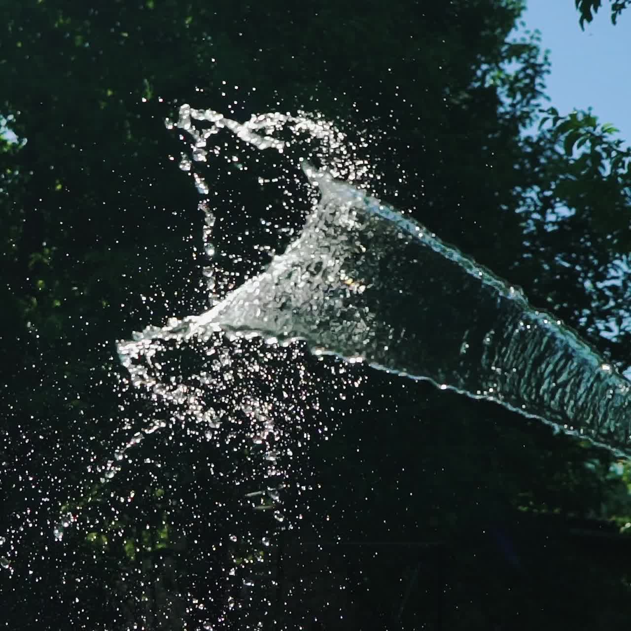 Flow of clean water from a rubber hose. Summer gardening. Slow Motion.