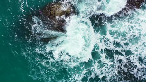 caribbean rocky coast and rough emerald sea splashing on the stones