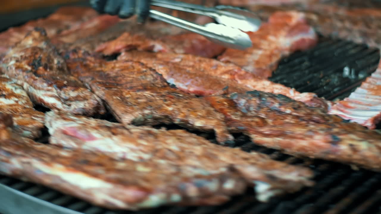 manos de hombre cocinando costillas de cordero en la parrilla. hombre asando carne.