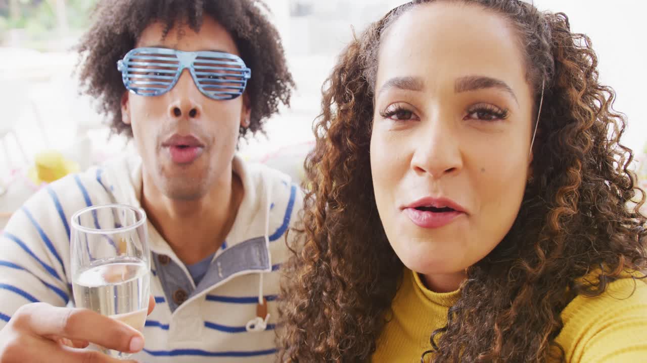 video de una feliz pareja diversa celebrando la víspera de año nuevo y haciendo una videollamada
