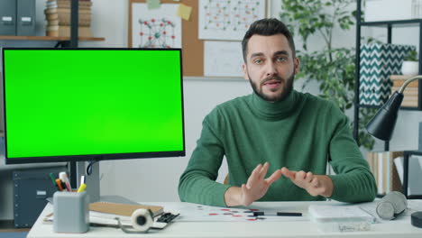 man in green sweater doing a video presentation/tutorial