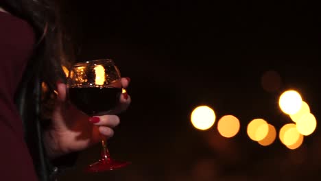 woman with wine glass at night