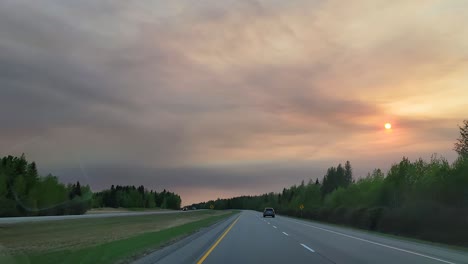 fox creek town outskirts on highway, haze smoke sky sunset alberta canada