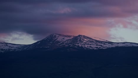 impresionante time-lapse de una cima de la montaña al anochecer en el invierno, la montaña vitosha, cubierta de nieve y bañada en los colores del sol poniente