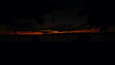 a magnificent sunset view with chairs and a silhouetted flag in sight