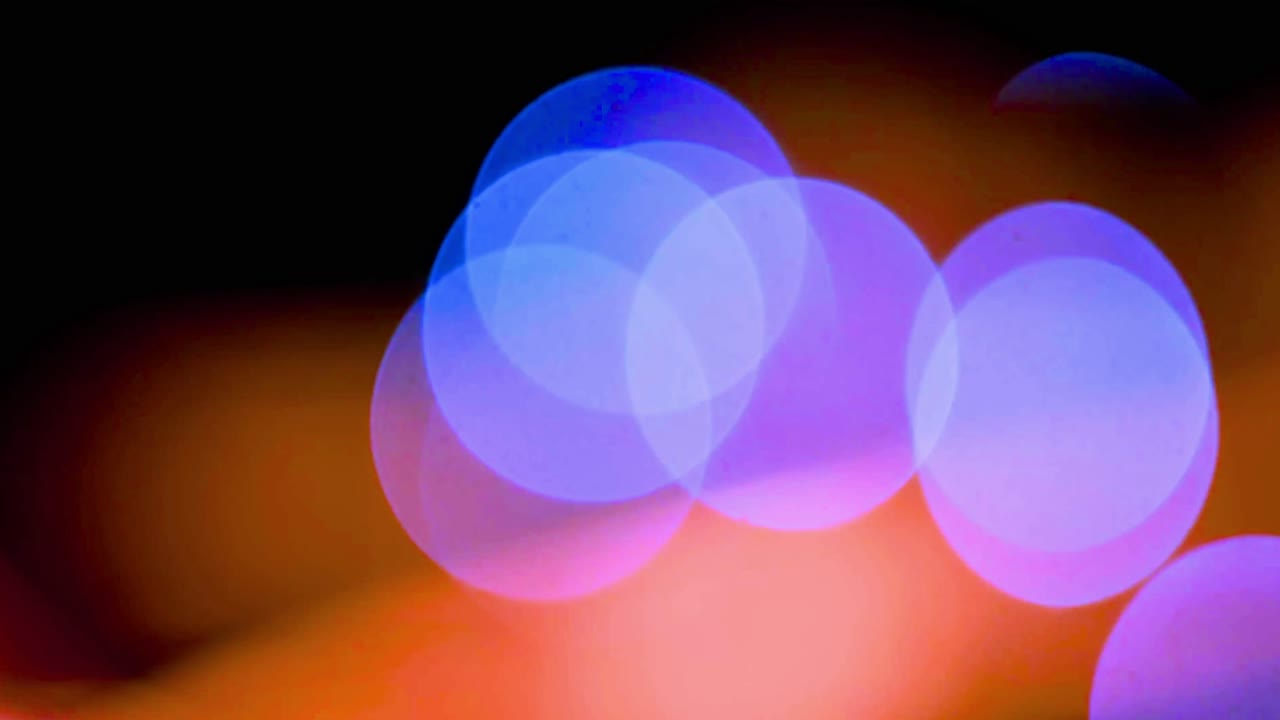 Bevægelige lilla og blå bokeh-lys på en orange baggrund