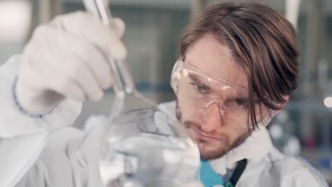 Científico-En-El-Laboratorio-Examina-Un-Matraz-Con-Agua