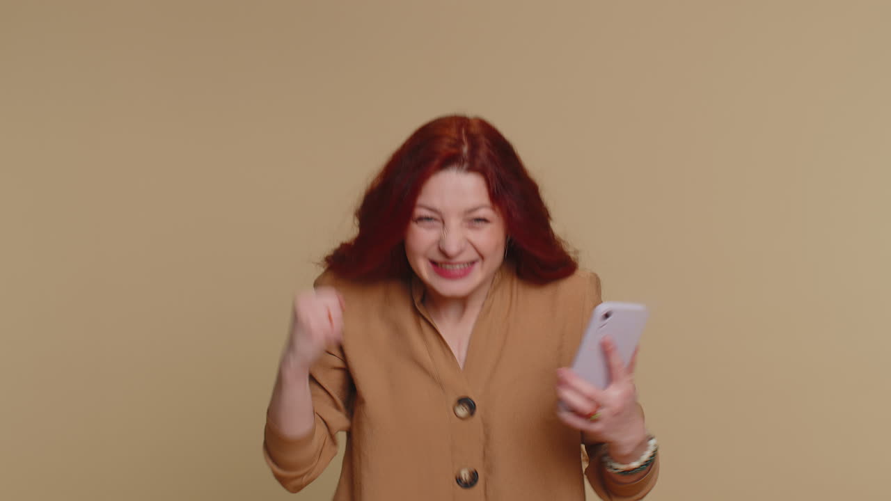 Felice donna eccitata usa il telefono cellulare dire wow sì scoperto grande grande notizia di vittoria facendo il gesto del vincitore
