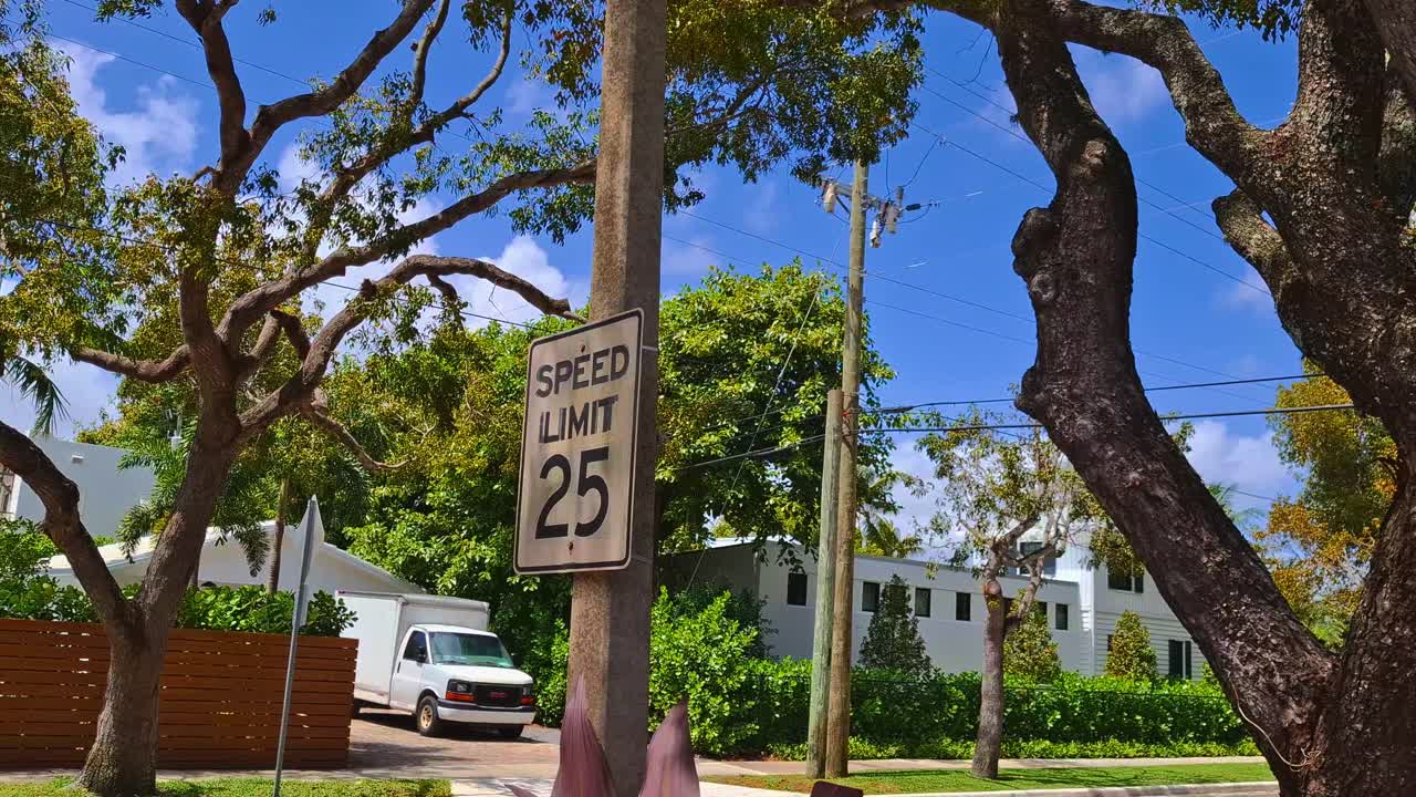 플로리다 팜비치에서 열대 나뭇잎과 함께 있는 속도 제한 25 표지판