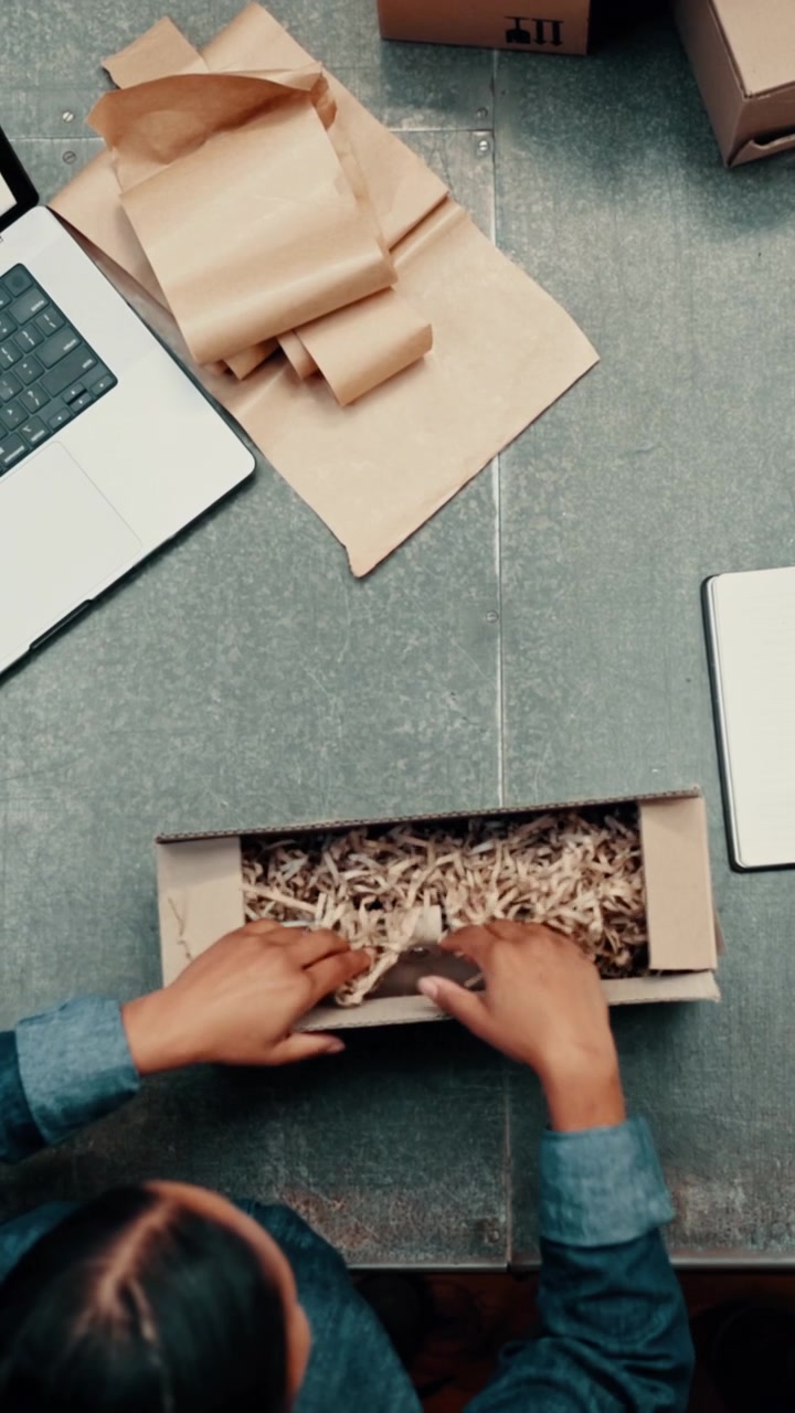 Two People Packing a Cardboard Box for Shipping in a Small Business