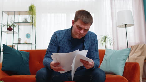 stressed angry man freelancer reviewing failure mistake charts and graphs and throwing papers in air