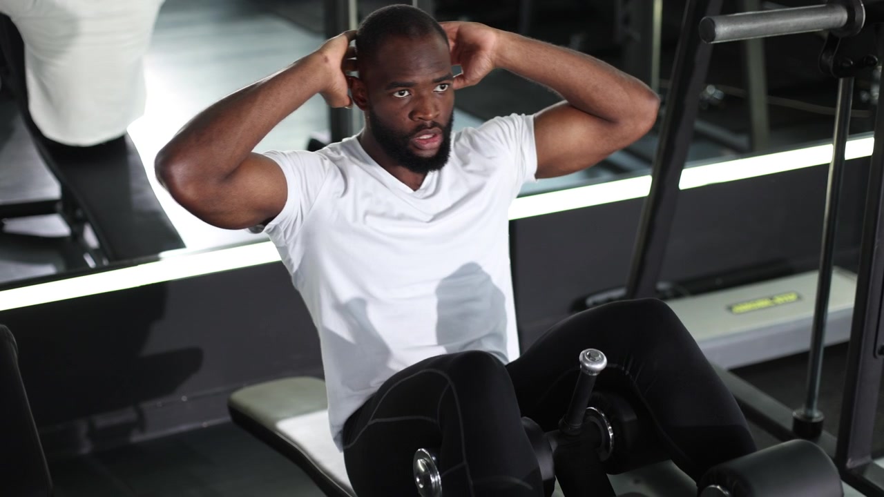 Muscular African American Man Performing Sit-ups in a Modern Gym