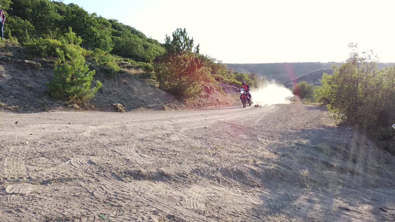 Off-Road Dirt Bike Rally with Spectators on a Dusty Track