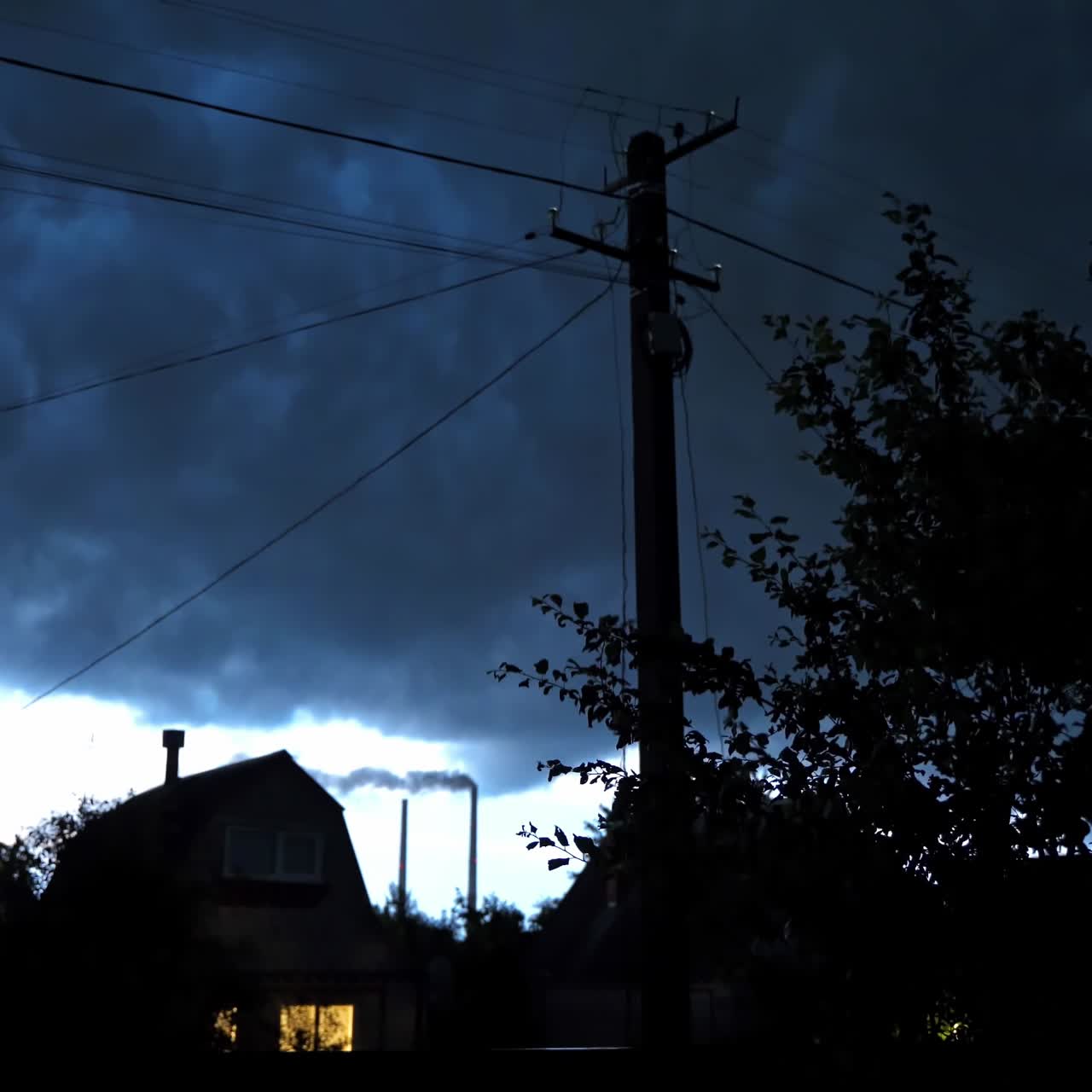 Thunderstorm in the countryside. Lightning on the dark sky in the evening. Dark storm filled sky over the rural houses in summer.