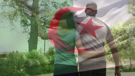 animación de la bandera de argelia sobre una pareja afroamericana abrazándose y caminando en el jardín