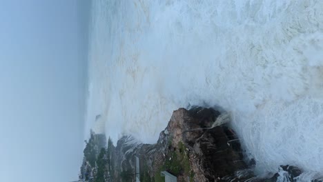 Vertical-drone-shot-of-powerful-sea-waves-crashing-shore-of-Dominican-Republic