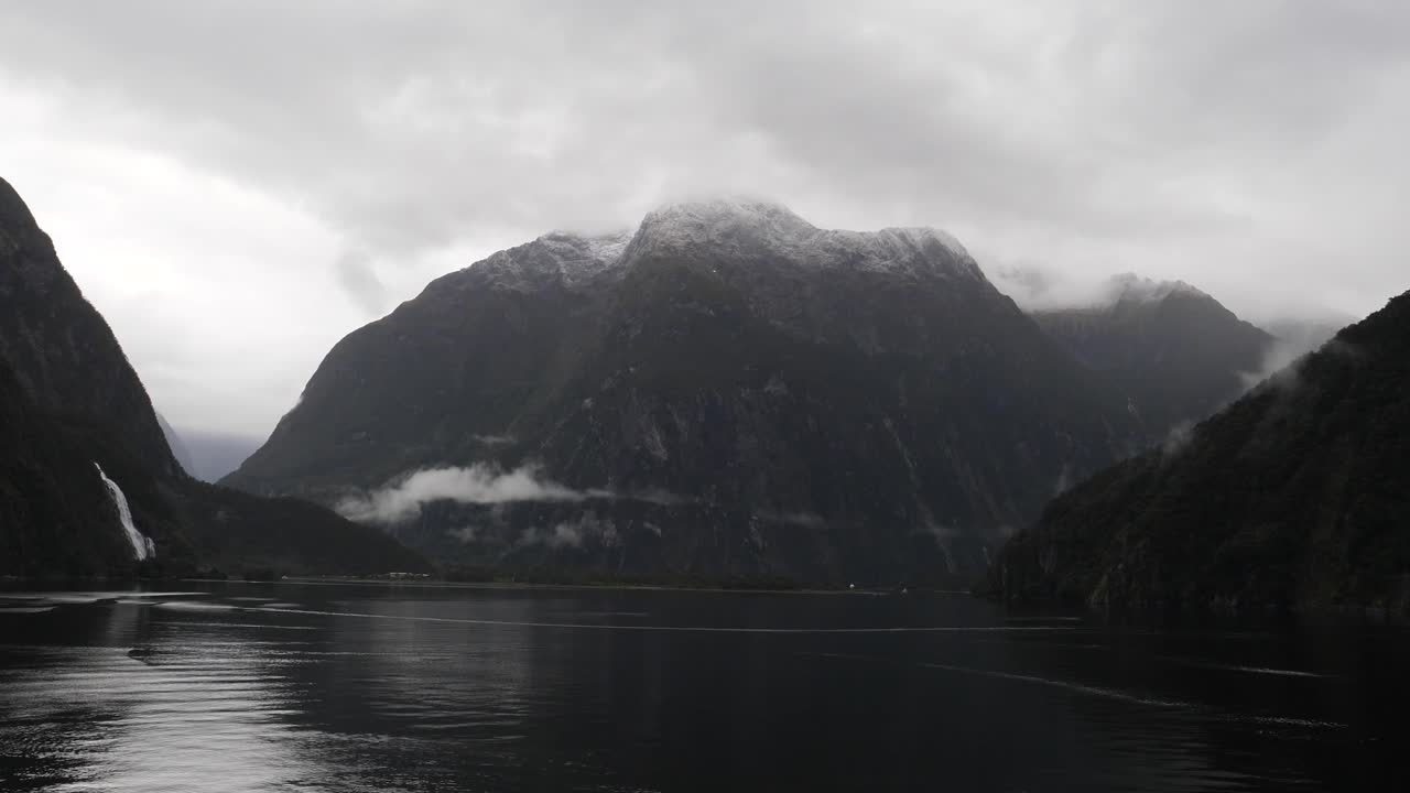 Scenic cruising at Milford Sound (Piopiotahi), Fiordland National Park on the South Island of New Zealand. Milford Sound surrounded by looming mountains and impressive sheer rock faces.