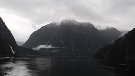 scenic cruising at milford sound (piopiotahi), fiordland national park on the south island of new zealand. milford sound surrounded by looming mountains and impressive sheer rock faces.